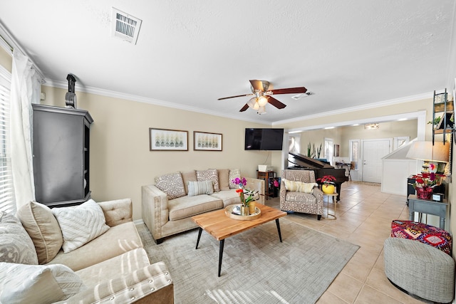 living room featuring crown molding, light tile patterned floors, a textured ceiling, and ceiling fan