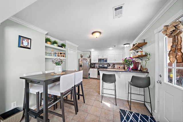 kitchen featuring stainless steel appliances, white cabinetry, ornamental molding, and kitchen peninsula