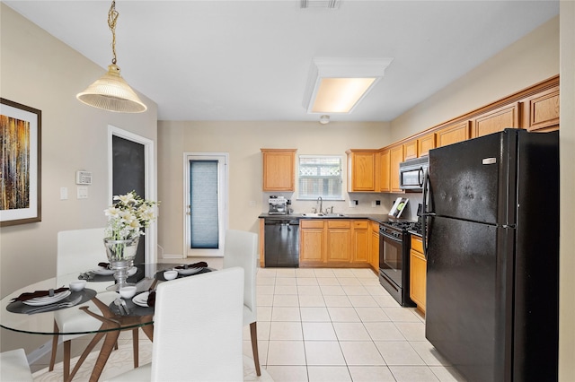 kitchen with light tile patterned flooring, decorative light fixtures, sink, and black appliances