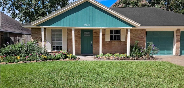 view of front of property featuring a porch, a garage, and a front yard