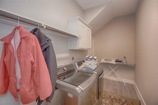 laundry area featuring washer and clothes dryer and cabinets