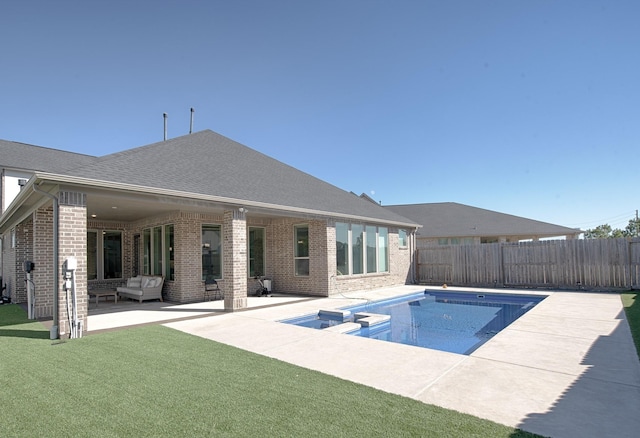 view of swimming pool with a patio area, a lawn, and an in ground hot tub