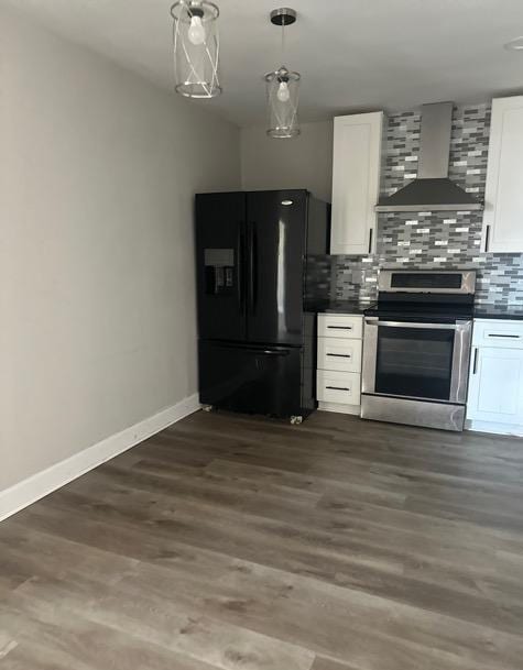 kitchen with stainless steel range with electric stovetop, white cabinetry, black fridge, decorative backsplash, and wall chimney exhaust hood