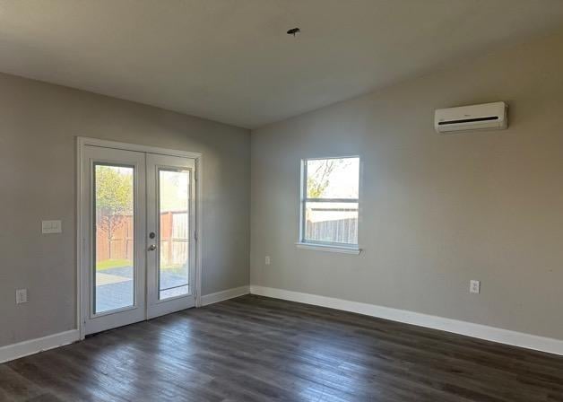 spare room featuring lofted ceiling, dark hardwood / wood-style floors, a wall mounted AC, and french doors