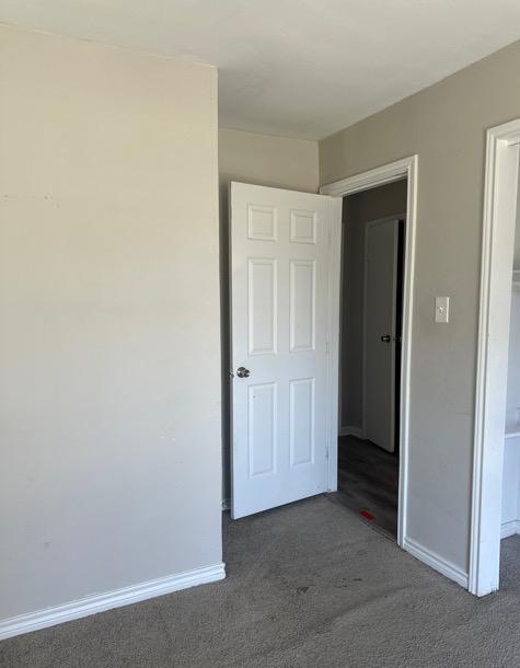 unfurnished bedroom featuring dark colored carpet