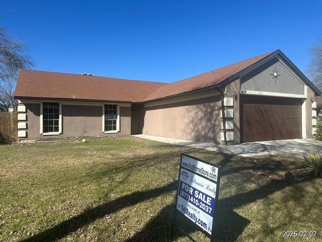 single story home featuring a garage and a front lawn