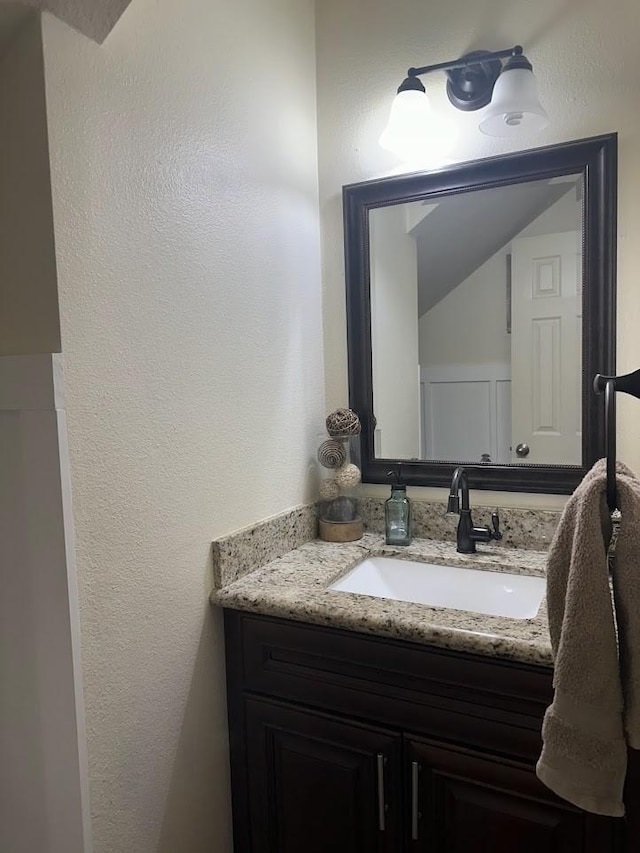 bathroom with vanity and vaulted ceiling