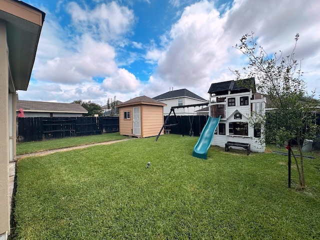 view of jungle gym with a yard and a storage unit