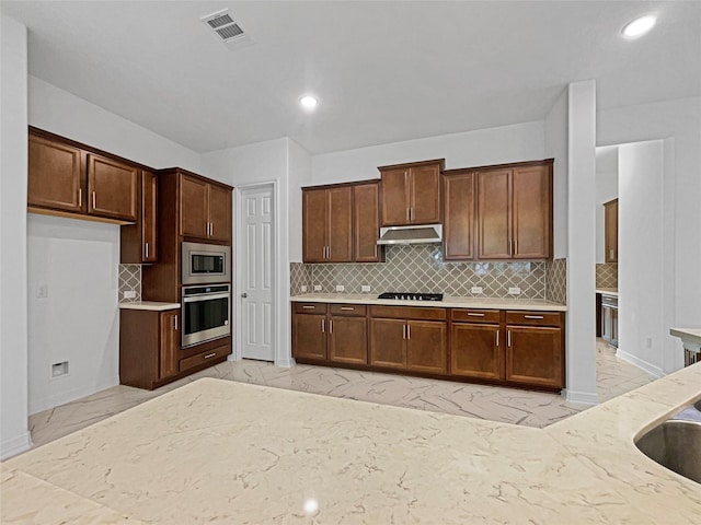 kitchen with stainless steel appliances and backsplash