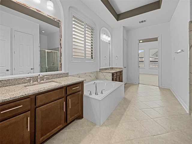 bathroom with tile patterned flooring, vanity, plus walk in shower, and a raised ceiling