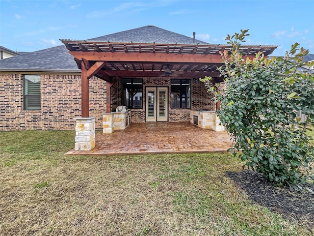 rear view of house with a pergola, a patio area, and a lawn