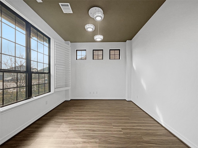 unfurnished room featuring plenty of natural light and dark hardwood / wood-style floors