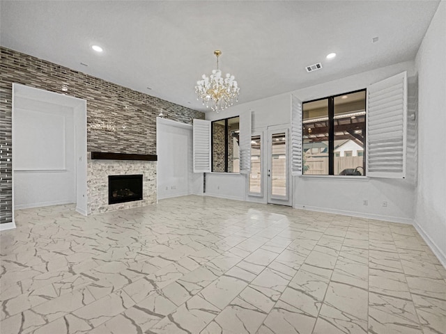 unfurnished living room featuring a large fireplace and a notable chandelier