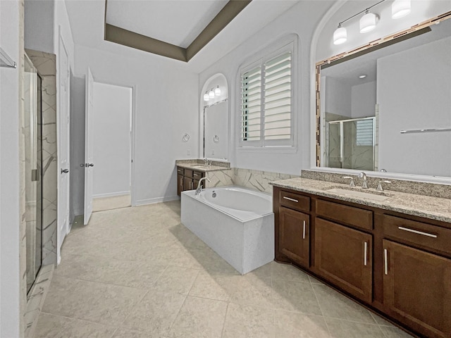 bathroom featuring vanity, tile patterned flooring, plus walk in shower, and a raised ceiling