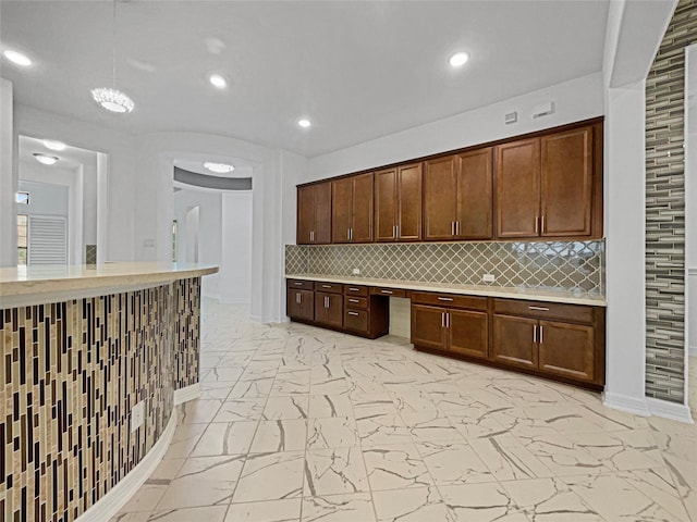 kitchen with built in desk and decorative backsplash