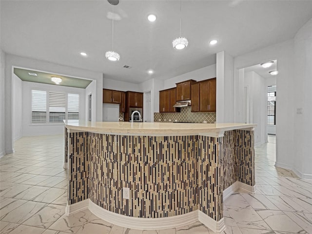 kitchen with pendant lighting, sink, and tasteful backsplash