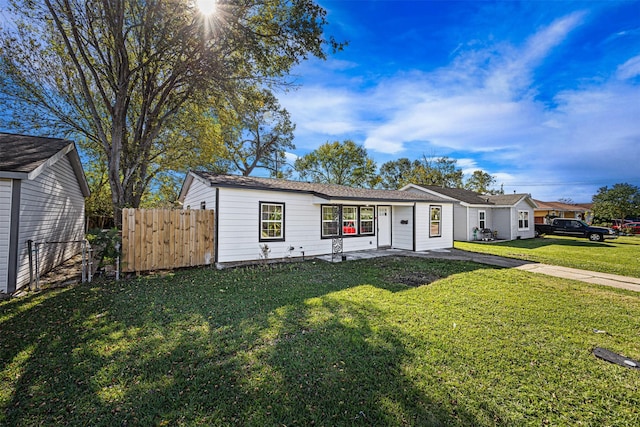 view of front of house with a front yard and fence