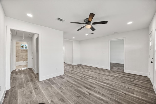 spare room featuring visible vents, wood finished floors, attic access, and baseboards