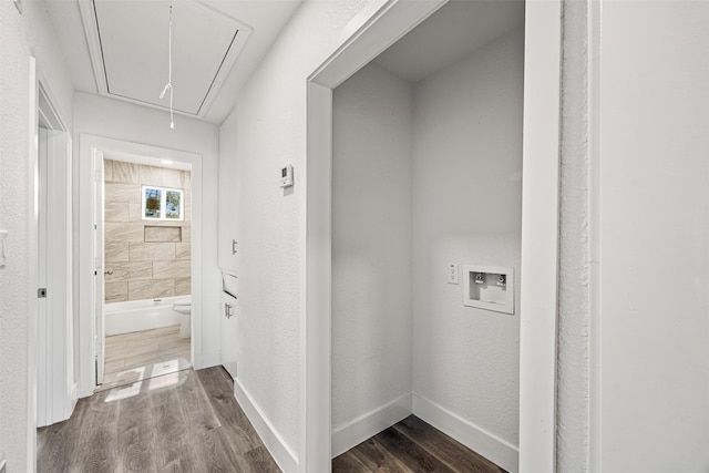 hallway with attic access, baseboards, dark wood finished floors, and a textured wall