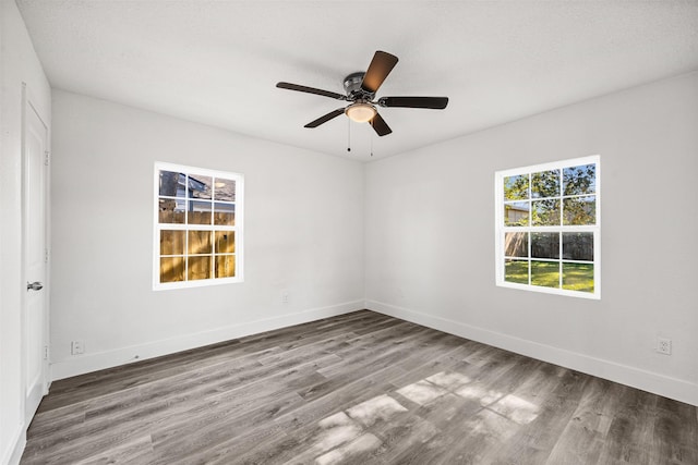 unfurnished room featuring ceiling fan, wood finished floors, and baseboards