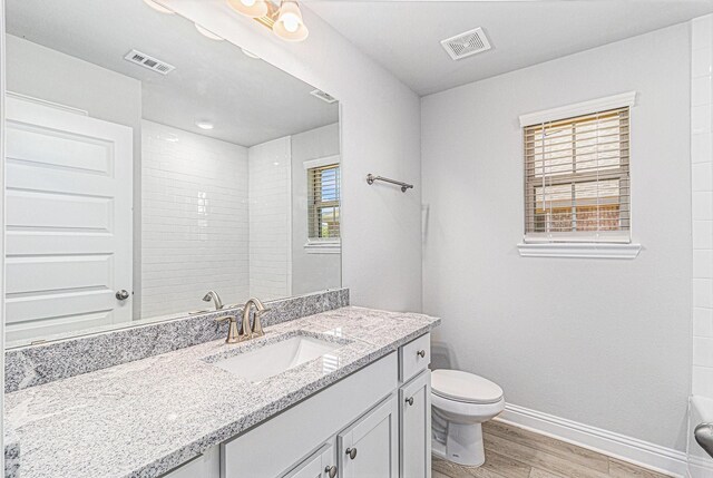 bathroom featuring wood-type flooring, vanity, and toilet