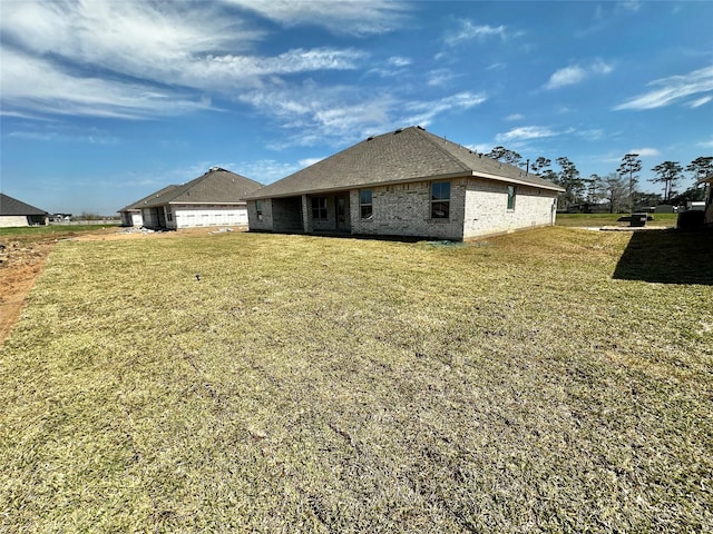 rear view of property with brick siding and a lawn