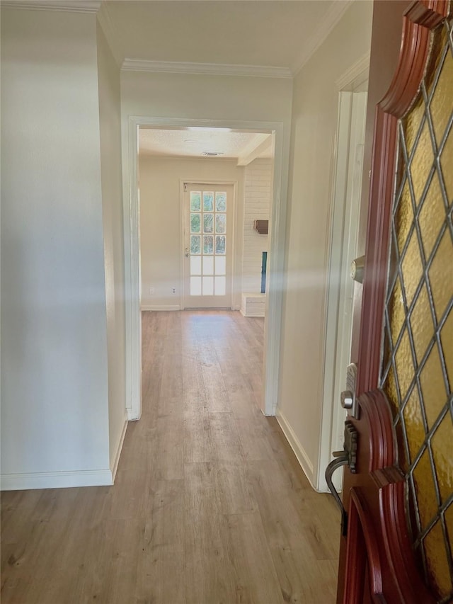 corridor with crown molding and light hardwood / wood-style flooring