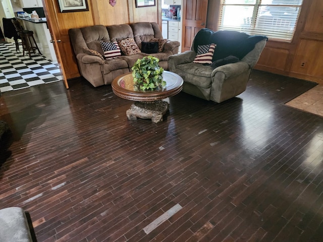 living room with dark wood-type flooring and wood walls