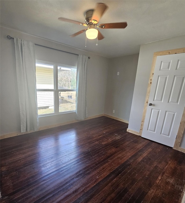 empty room featuring dark wood-type flooring and ceiling fan