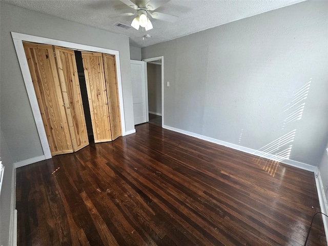 unfurnished bedroom with dark hardwood / wood-style flooring, ceiling fan, a closet, and a textured ceiling