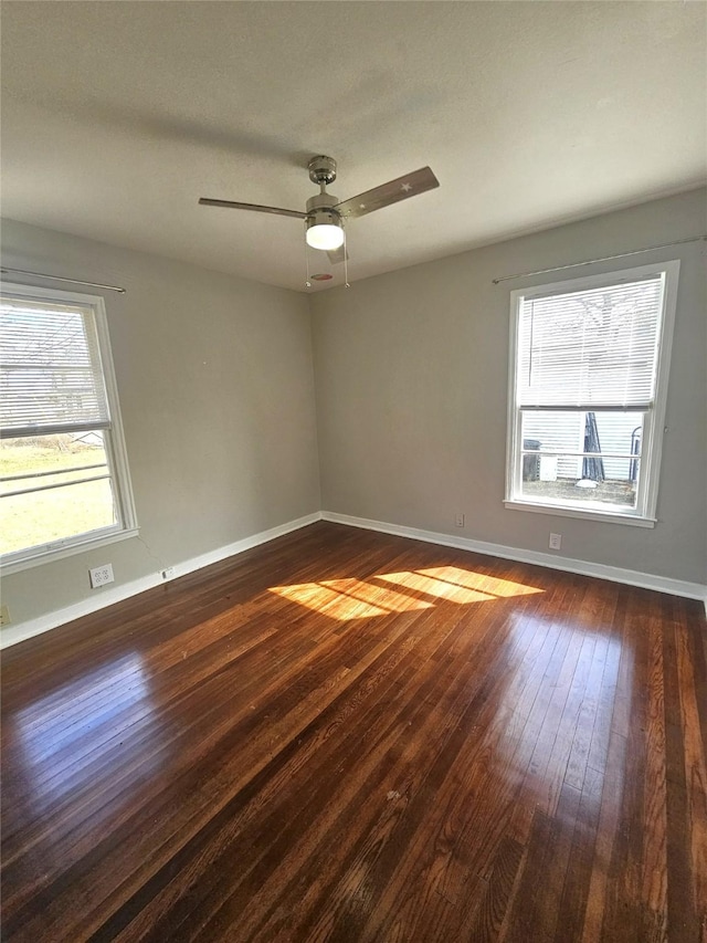 spare room with dark wood-type flooring and ceiling fan