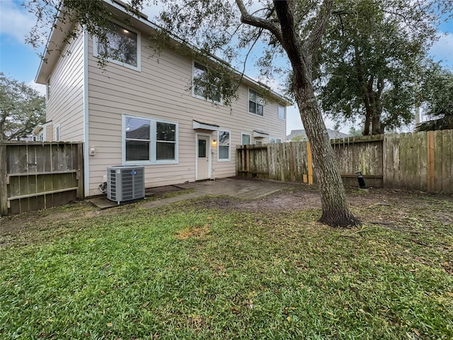 rear view of house with a yard and central air condition unit