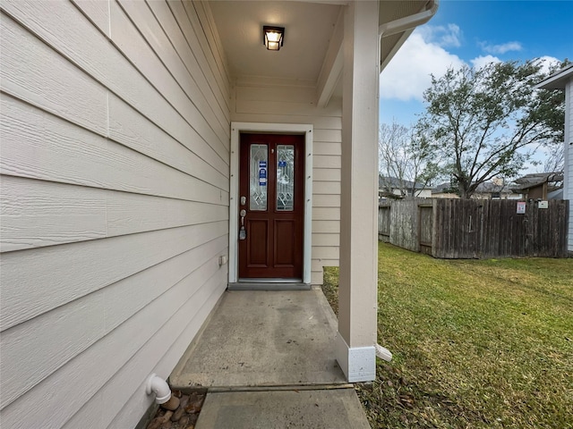 view of exterior entry with a yard