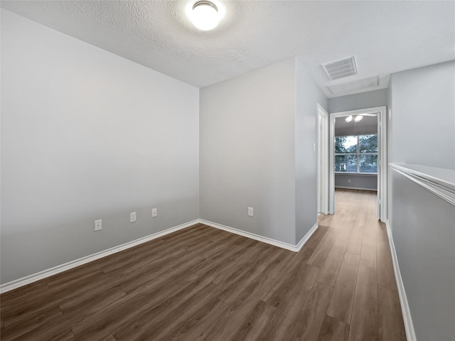 unfurnished room with dark hardwood / wood-style floors and a textured ceiling