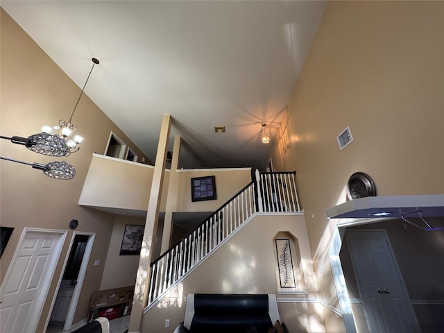 stairs with a towering ceiling and a chandelier