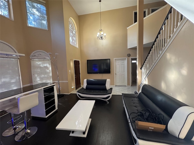 living room with an inviting chandelier, dark hardwood / wood-style floors, and a high ceiling