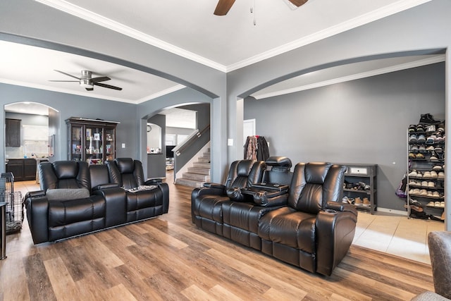 living room with wood-type flooring, crown molding, and ceiling fan