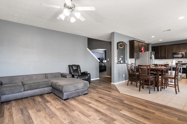 living room with light hardwood / wood-style flooring and ceiling fan