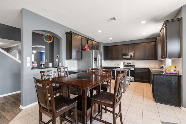 dining area featuring sink and light tile patterned flooring