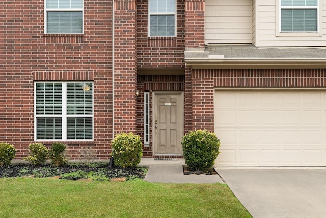 entrance to property featuring a garage and a yard