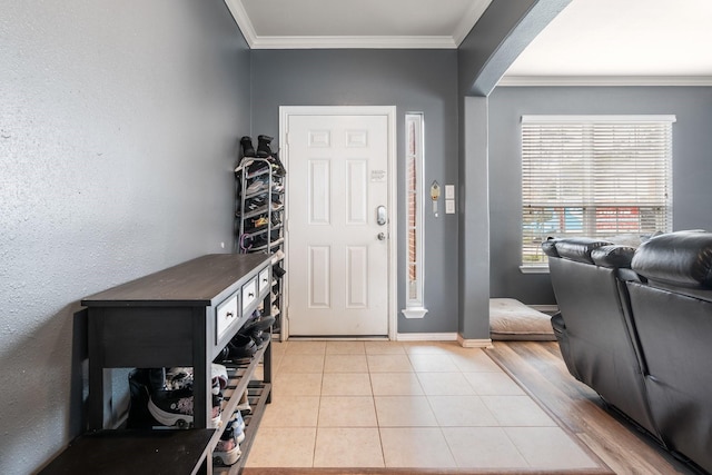 foyer with ornamental molding and light tile patterned flooring