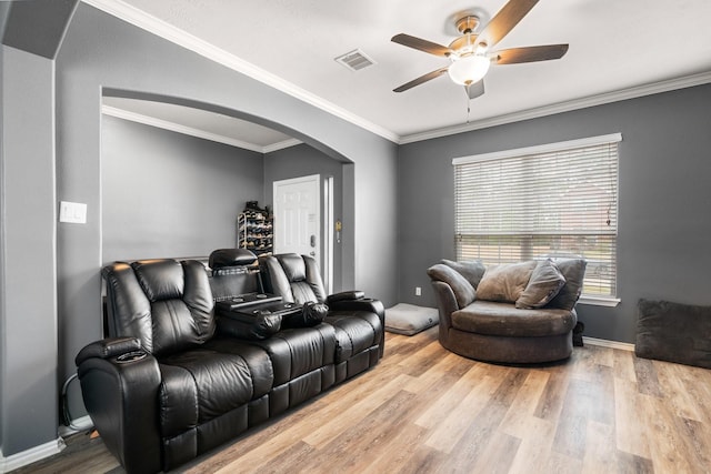 living room with wood-type flooring, ornamental molding, and ceiling fan