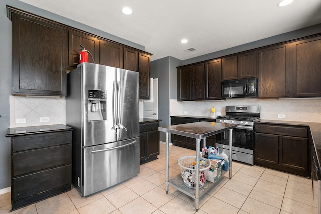 kitchen featuring light tile patterned floors, decorative backsplash, dark brown cabinets, and appliances with stainless steel finishes