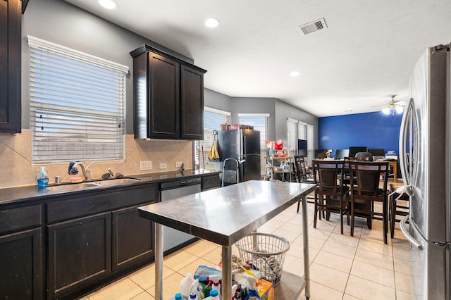 kitchen featuring sink, backsplash, light tile patterned floors, ceiling fan, and stainless steel appliances