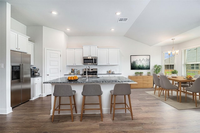 kitchen featuring stainless steel appliances, white cabinetry, a kitchen island with sink, and sink