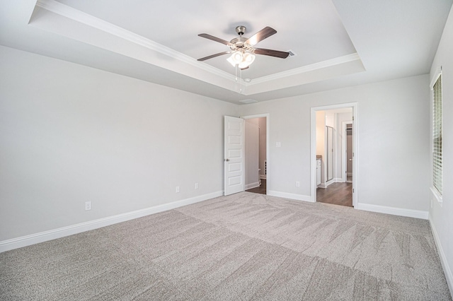 unfurnished bedroom featuring crown molding, a raised ceiling, ceiling fan, and carpet