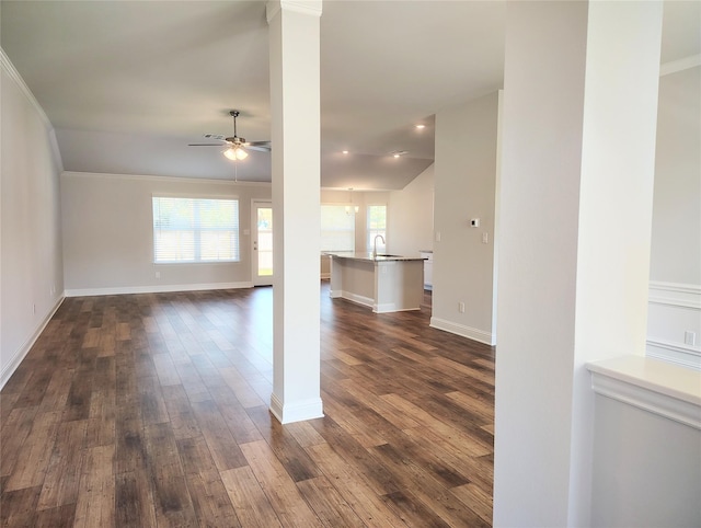 unfurnished living room with ornate columns, ceiling fan, sink, and dark hardwood / wood-style flooring