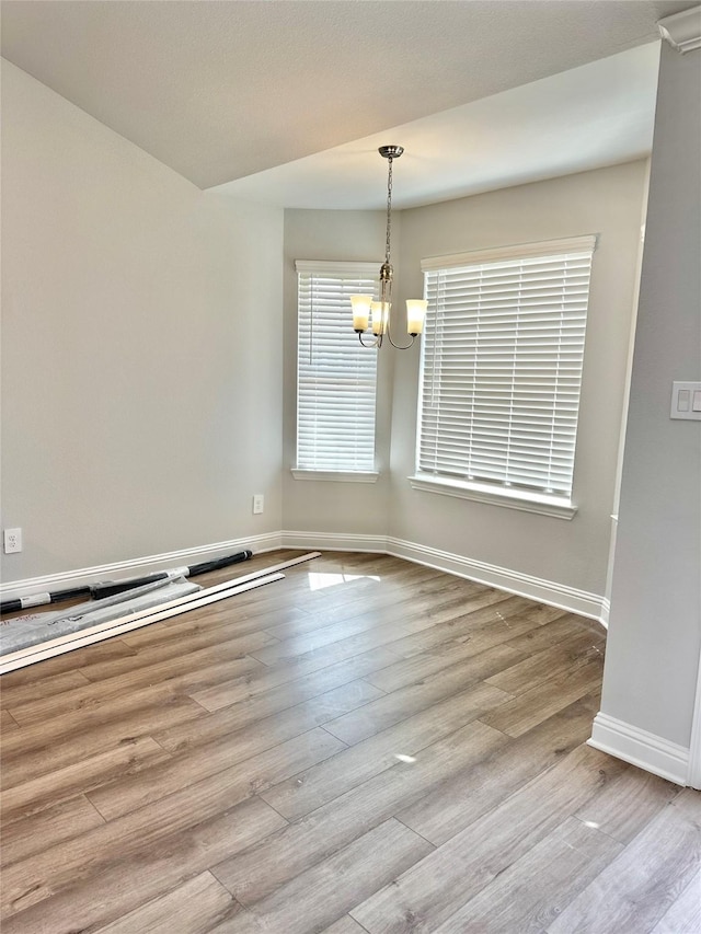 4318 Karam Lndg, Dickinson, TX 77539 - spare room with baseboards, a notable chandelier, and wood finished floors