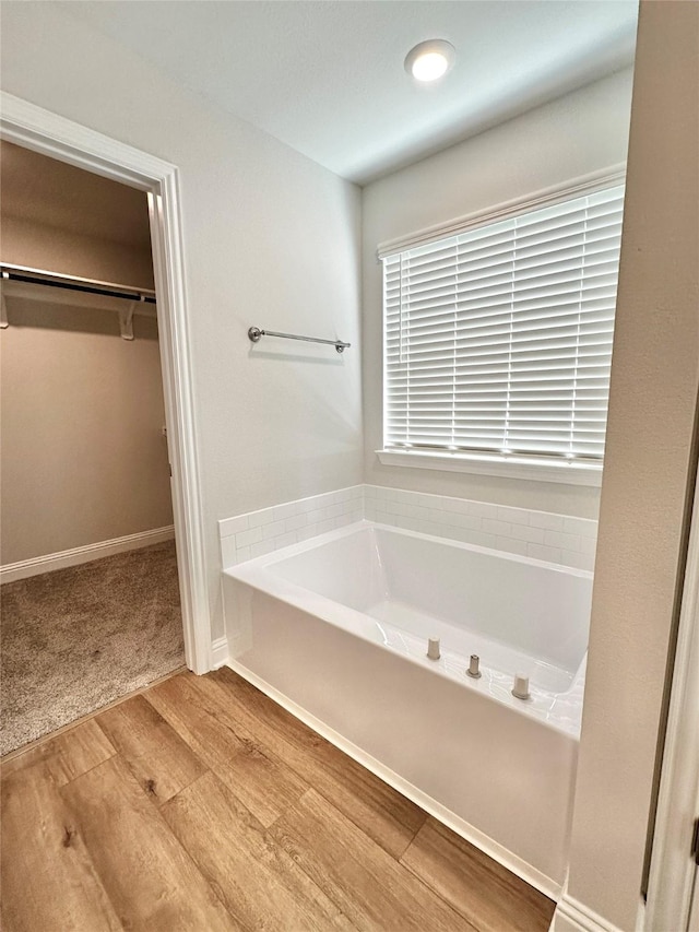 4318 Karam Lndg, Dickinson, TX 77539 - full bathroom featuring a walk in closet, a garden tub, and wood finished floors