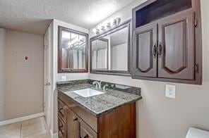 bathroom with vanity, tile patterned floors, toilet, and a textured ceiling